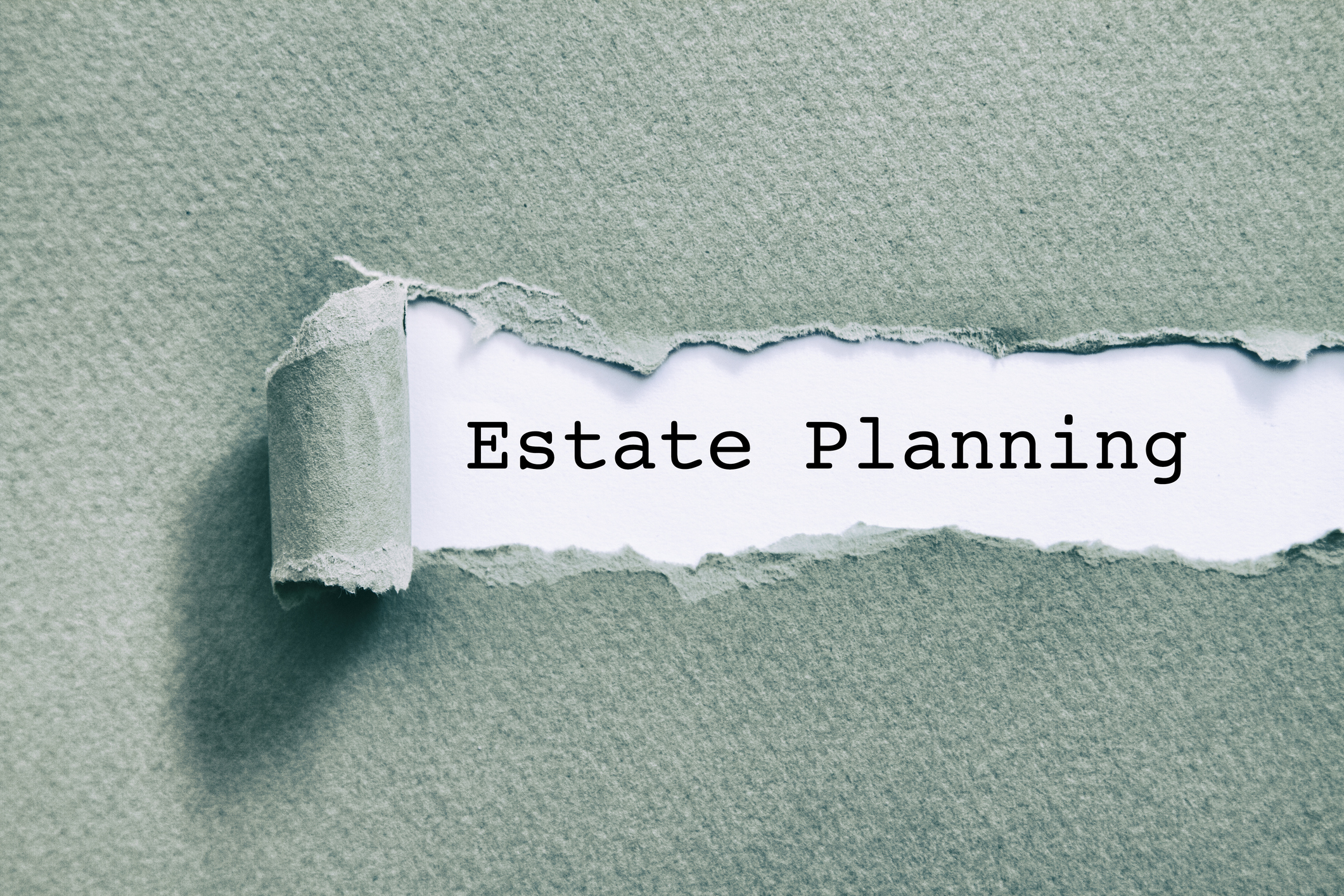 Estate planning written under torn paper on a light green background