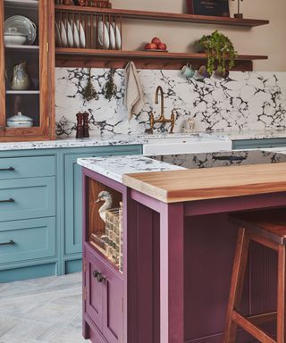 A blue and marble kitchen with a purple kitchen island