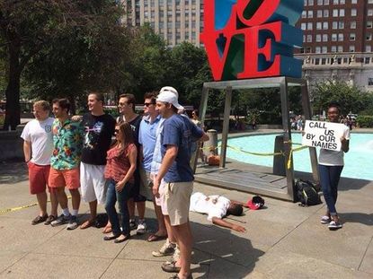 Black artist poses as dead body at Philly's 'Love' sculpture, tourists continue taking photos