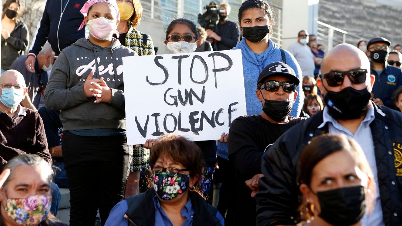 A girl holds a sign reading &amp;#039;Stop Gun Violence&amp;#039; as people attend a vigil 