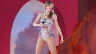 Taylor Swift smiles as she performs a song during The Eras Tour in Tokyo, Japan