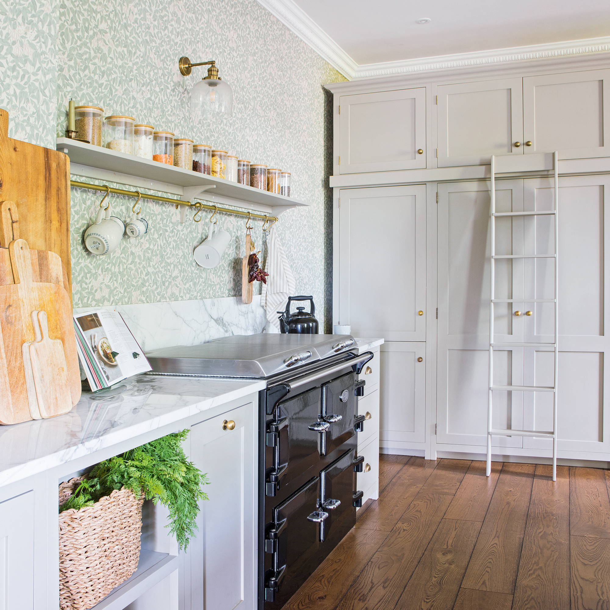 a country-style kitchen with opening shelving, a black Aga and tall cupboards with a ladder