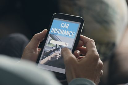 A man searches for car insurance on his smartphone.