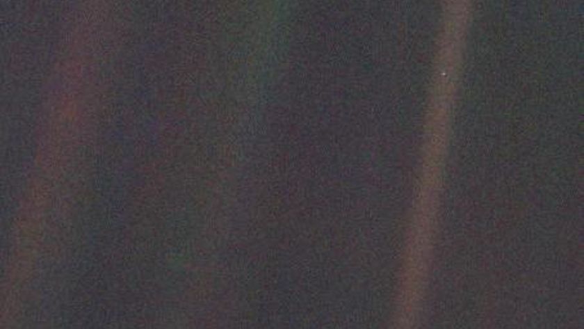 A fuzzy image of space with one light blue pixel