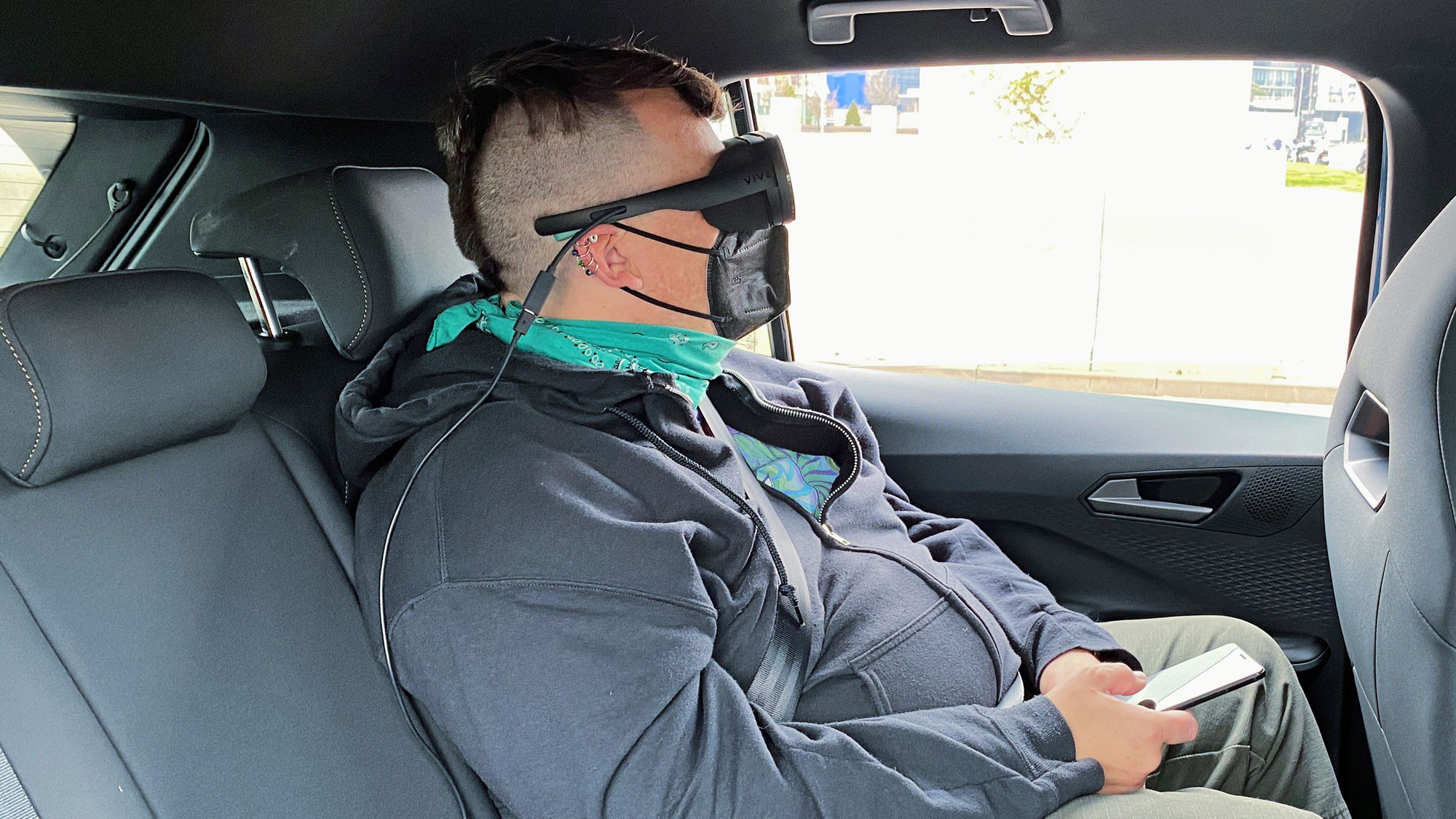 Woman sitting in rear seat of car wearing a VR headset