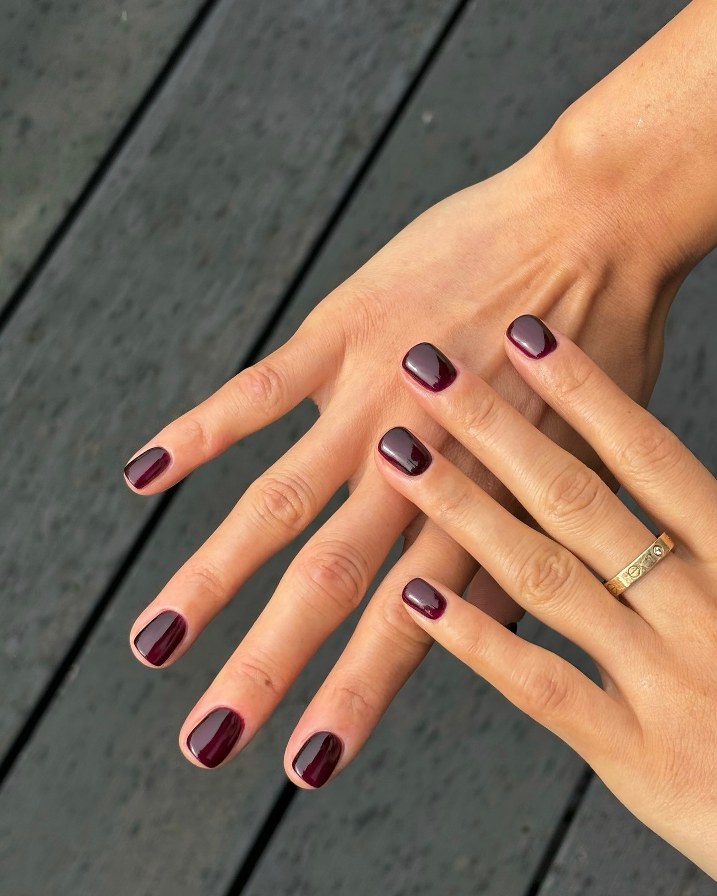A manicure by @paintedbyjools with short dark red nail polish