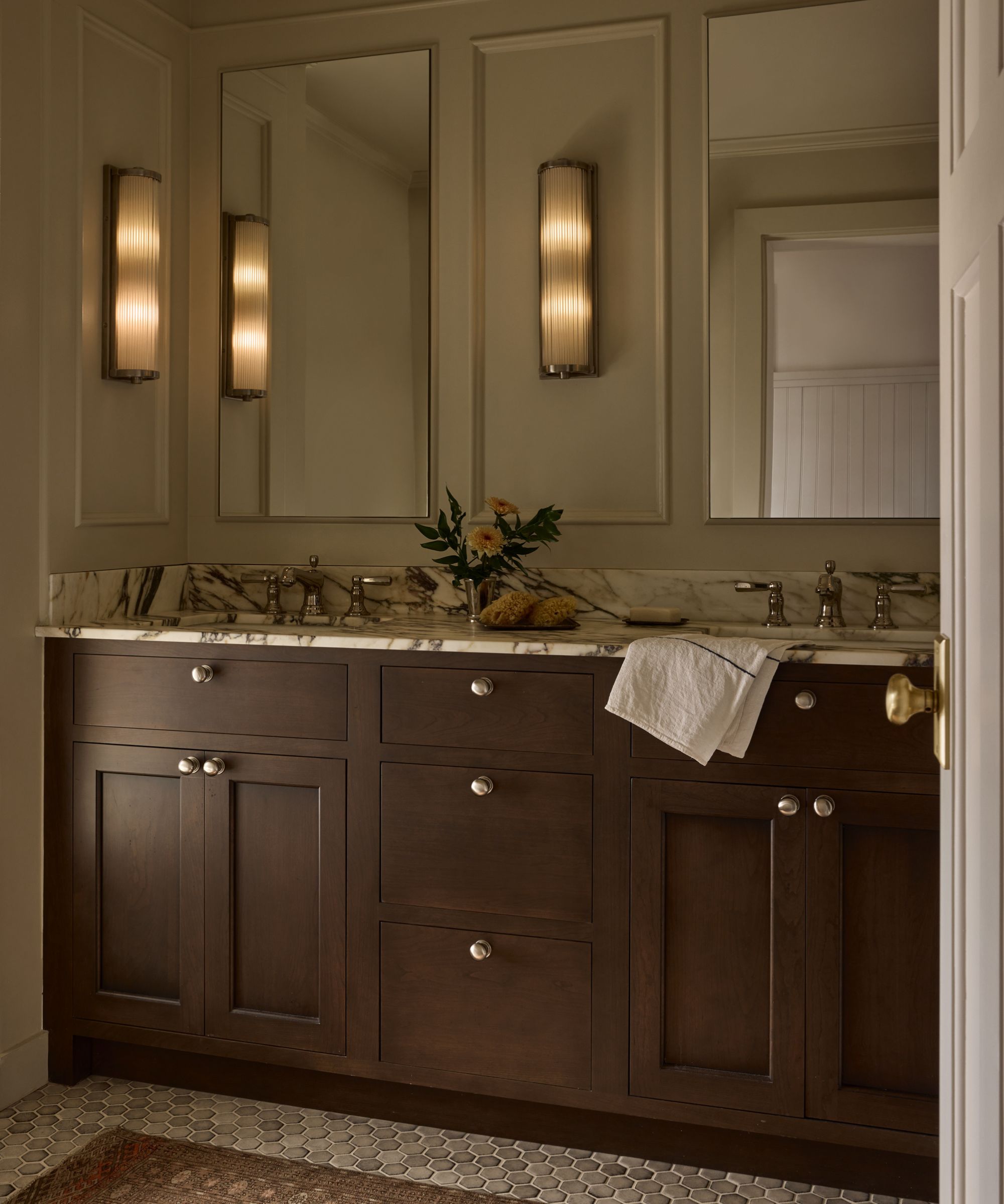 Cream bathroom with dark wooden vanity and veined marble countertop