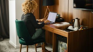 Woman on a laptop in a luxury hotel room