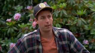 Adam Sandler standing with arms on a club, looking a little annoyed, in Happy Gilmore. 