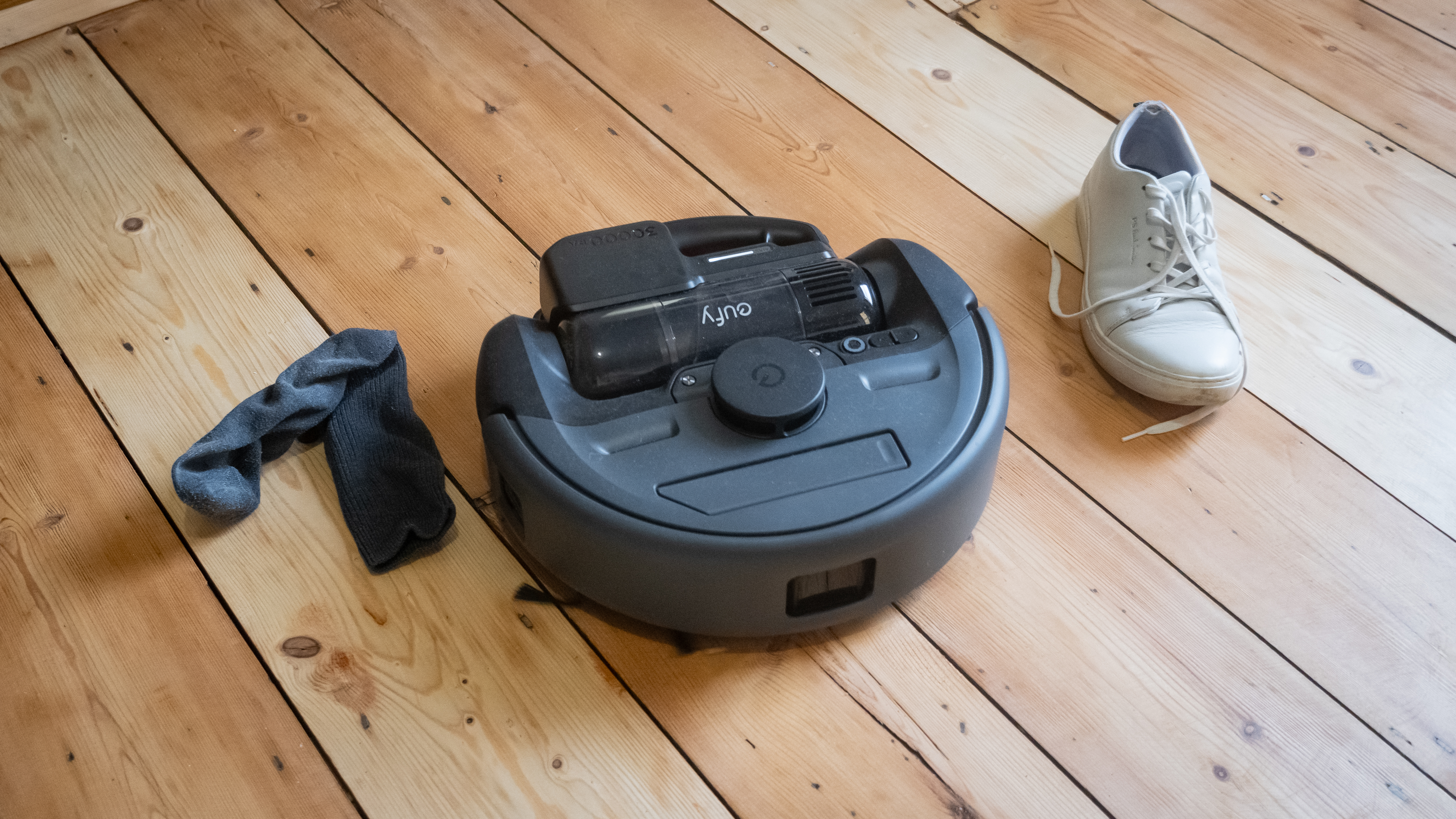 Eufy E20 next to a sock and shoe, ready for obstacle avoidance tests