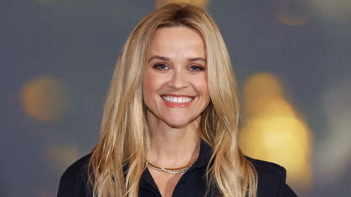 Reese Witherspoon's living room with white sofa and wood shelves ...