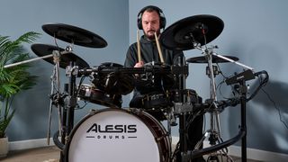 Man playing Alesis Strata Prime electronic drum set