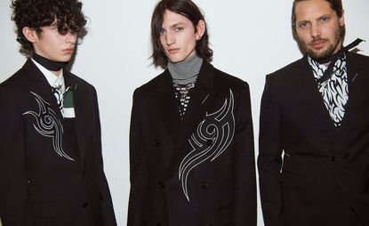 3 male models in dark clothing looking into the camera
