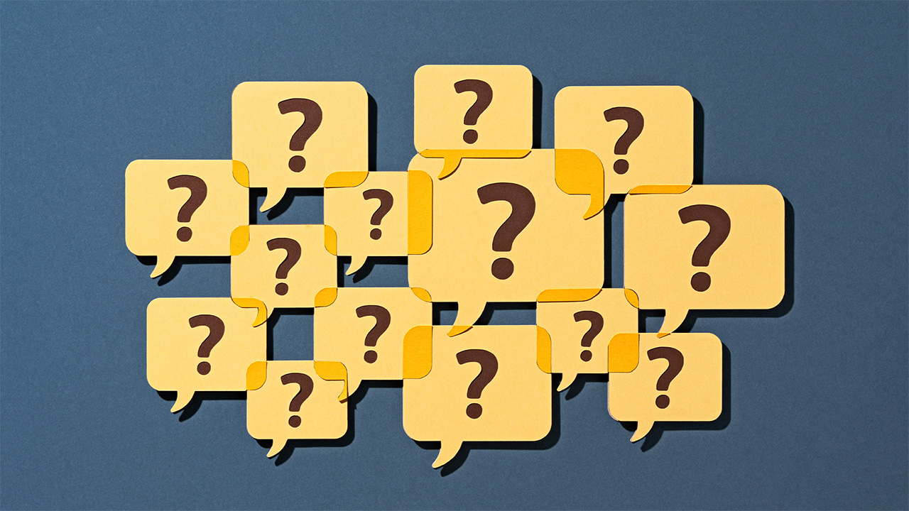 Cartoon graphic of a crowd of question marks in yellow speech bubbles, on a dark blue background