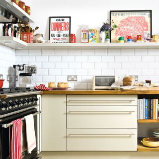 display shelves with downlights in kitchen with white wall tiles cream pot drawers and wooden counter tops