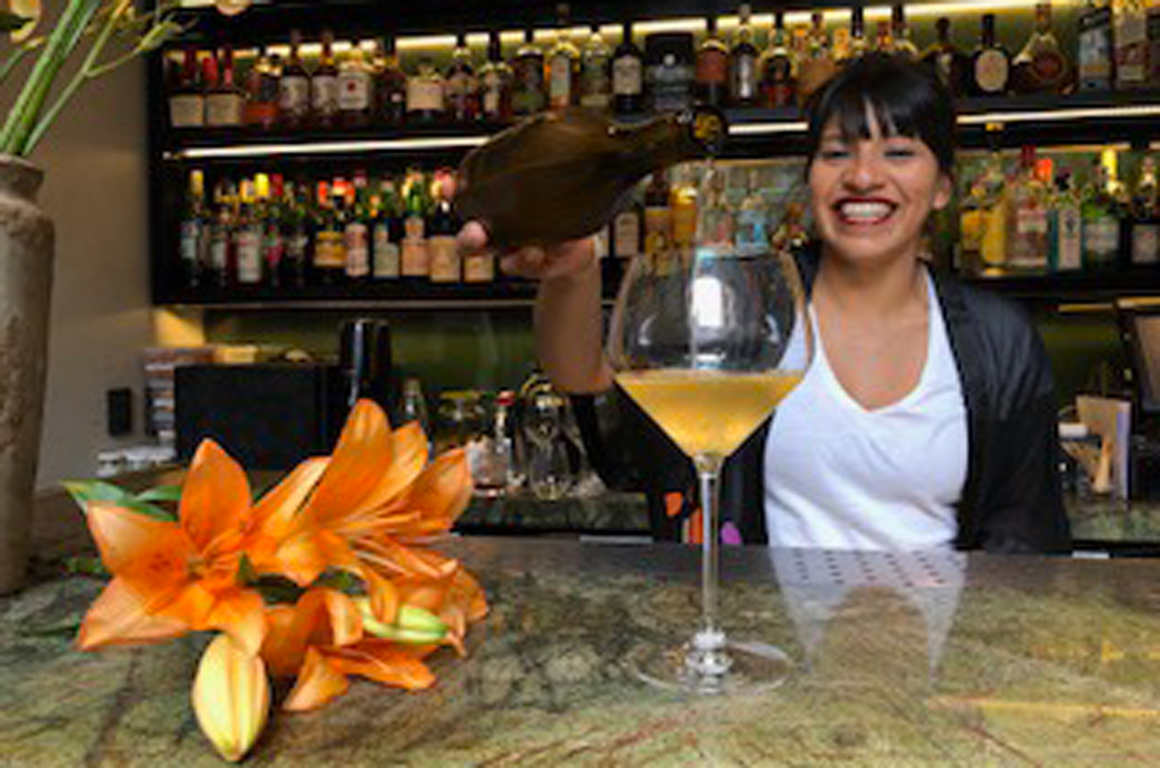 A female bartender serving a drink