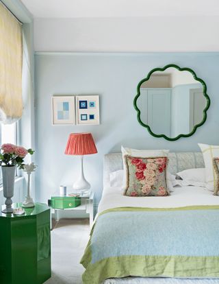 pale blue bedroom with a mirror over the bed