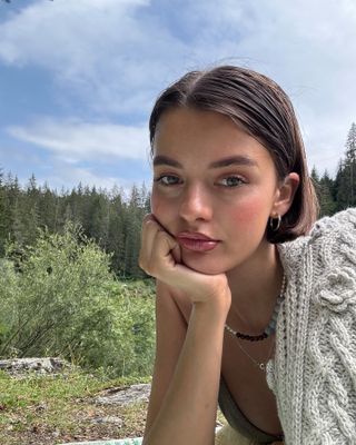 Mary posing outside with thick, healthy brows.