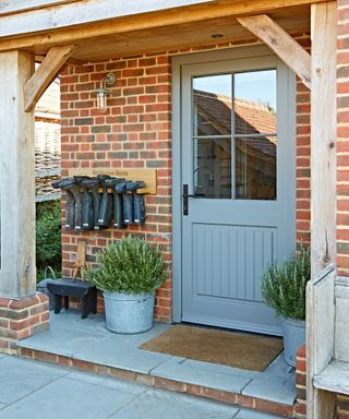 pale blue front door with oak porch and stone step
