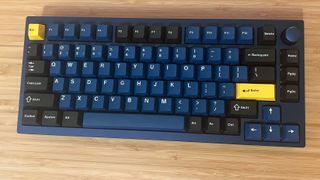 Lemokey P1 Pro blue and yellow gaming keyboard on a wooden desk