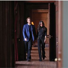 Prince Harry and Meghan Markle walking through a doorway