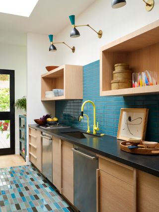 teal kitchen with timber cabinets and light fixtures above open shelving