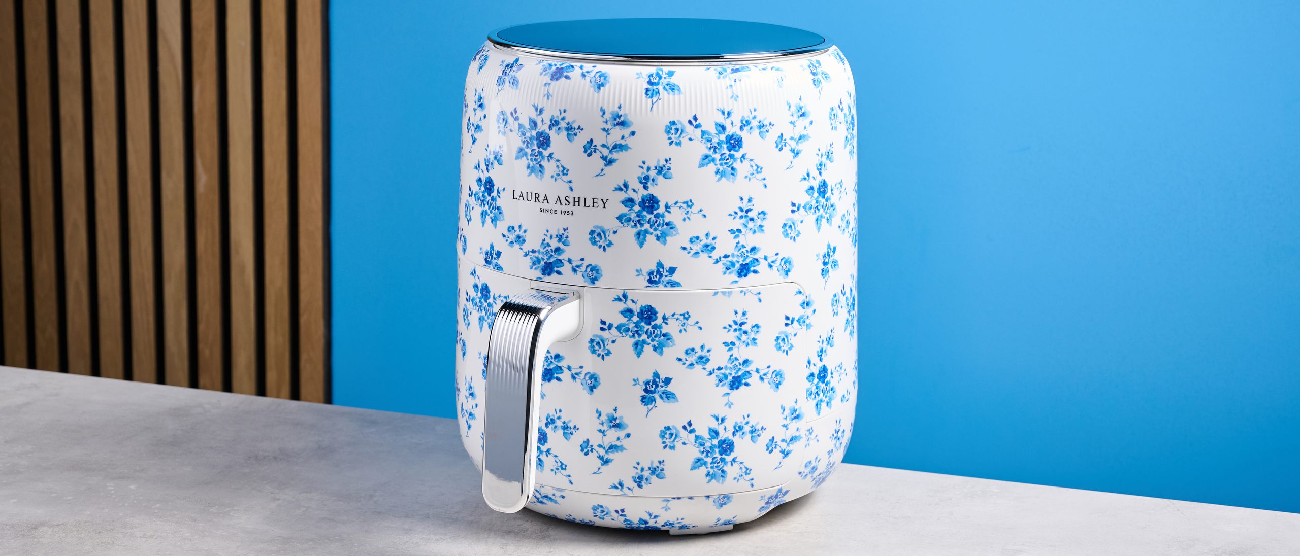 the Laura Ashley Air Fryer in blue and white floral print, showing the air fryer basket and black touchscreen on the top