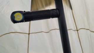 Olight Perun 2 attached to a tent pole inside a yurt tent.