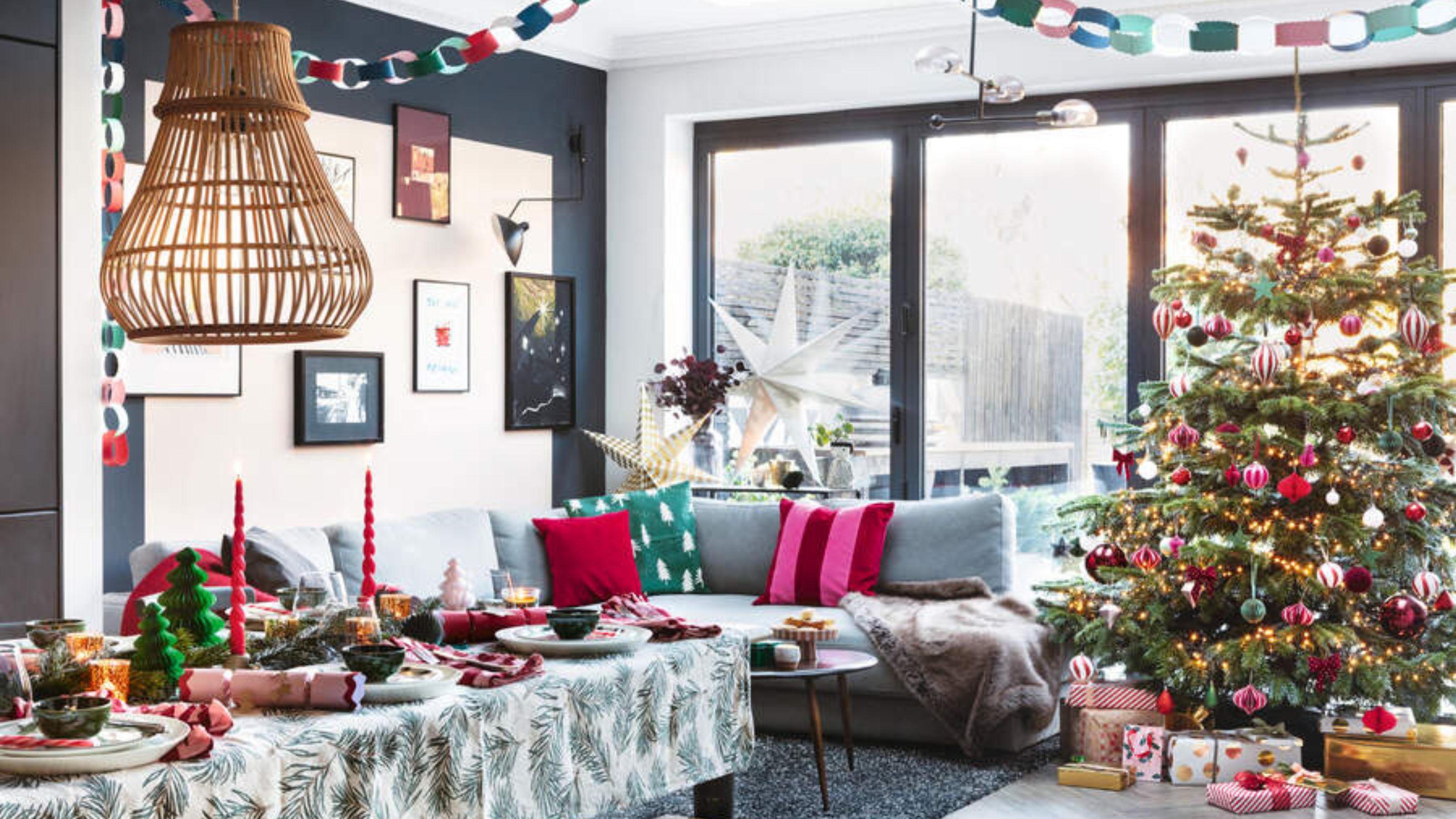 Real Christmas tree in a dining room full of decorations, including a Christmas tablescape and presents under the tree