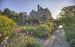 Britain's most romantic places to visit: the beautiful gardens at gravetye manor with pink tulips and seating area