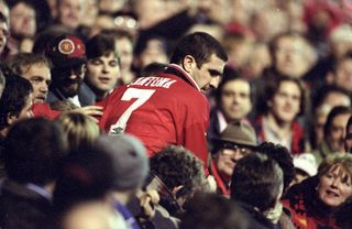 Eric Cantona surrounded by Manchester United fans after a match against Chelsea in December 1995.