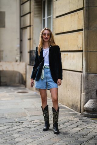 woman wearing blazer, white t-shirt, shorts, and cowboy boots