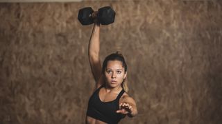 a photo of a woman doing a dumbbell snatch