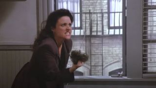 Elaine tosses George's toupee out the window on Seinfeld
