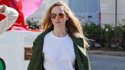 Jennifer Lawrence wears a white t shirt, trench coat, and denim skirt while out in los angeles