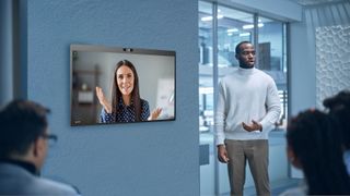 A presenter using a DTEN D7X Series to video conference with his woman colleague on screen.