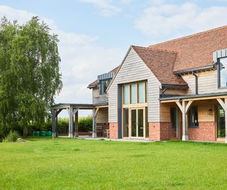 A lush green lawn in front of a large oak frame home