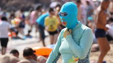 A Chinese beachgoer wearing a bathing suit and head mask 