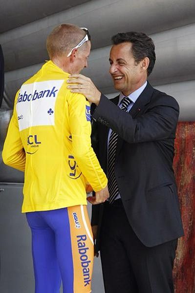 Rasmussen and Sarkozy share a laugh on the podium.