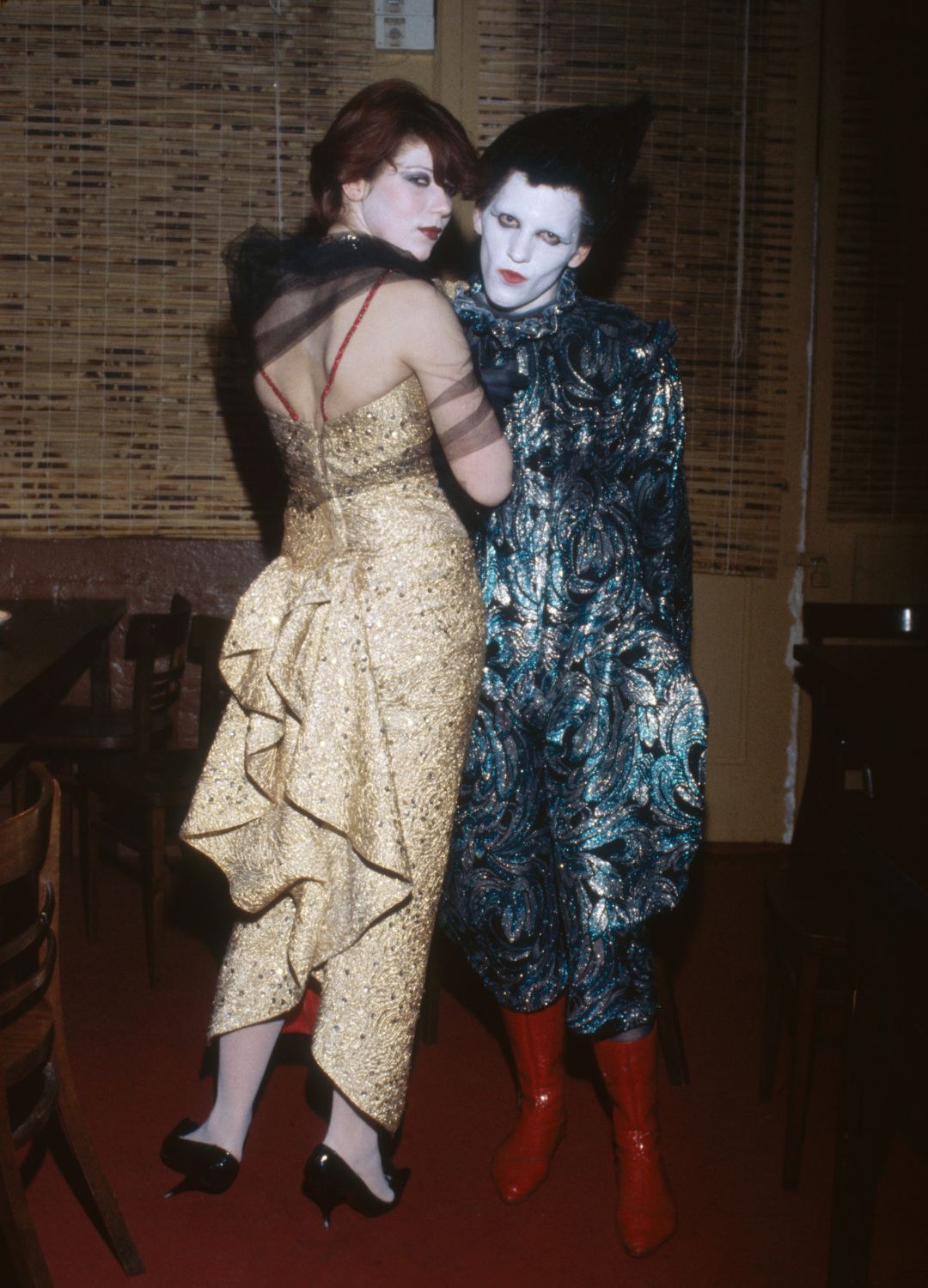 A couple with whitened faces and sparkling evening gowns at a New Romantics club, circa 1982.
