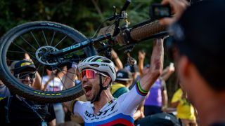 Nino Schurter celebrates his 33rd win holding his bike above his head