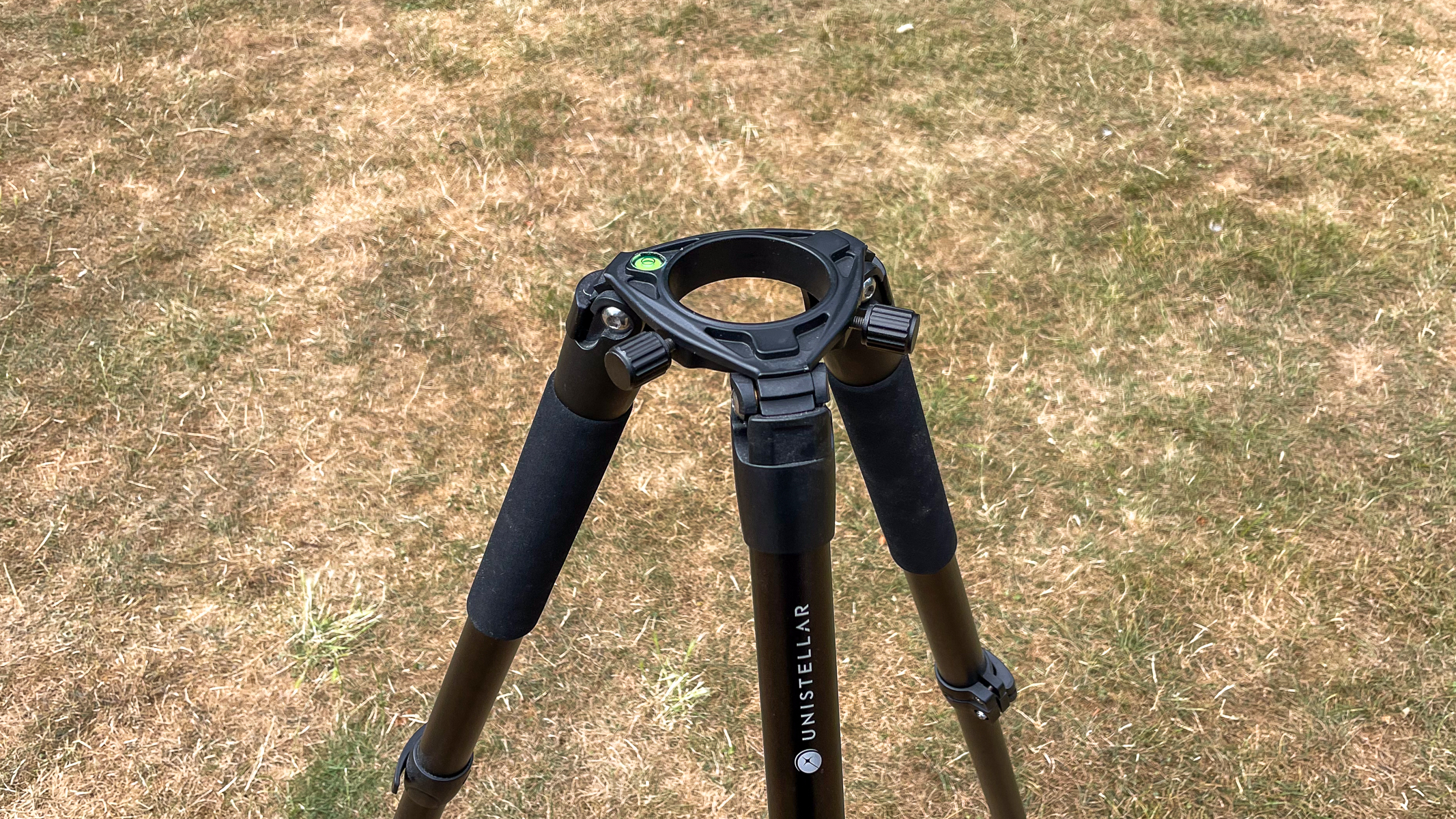 The Unistellar tripod against some grass.