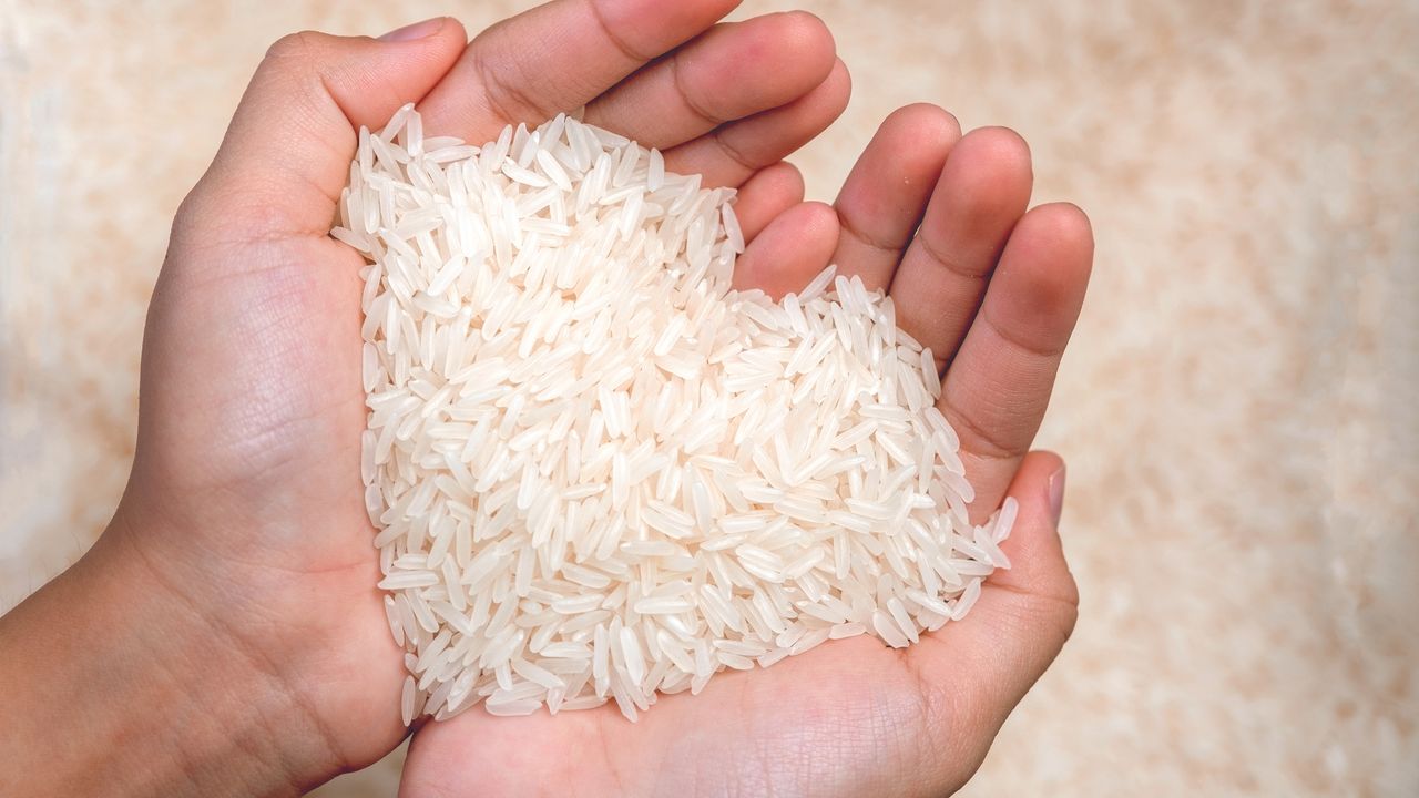 Person cupping their hands, holding white rice in a heart shape - for article on ways to clean with rice