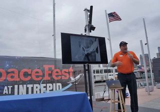 Mark Roberts, a tour guide at the Intrepid Air & Space Museum in New York, gives a talk about going to the bathroom in space on July 25, 2013, during SpaceFest. The picture he is pointing to on the screen shows a NASA engineer modestly demonstrating how an Apollo fecal collection bag works over a pair of plaid pants.