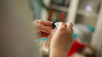 Woman cleaning smart watch with antibacterial wet wipe at home.