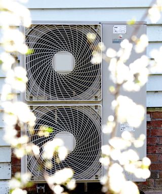 Exterior of house, with outdoor unit air source heat pump