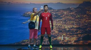 A man poses next to a waxwork of Cristiano Ronaldo at the forward's museum in Madeira in 2018.