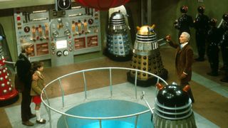 Peter Cushing's Doctor points at a Dalek bomb in their control room.