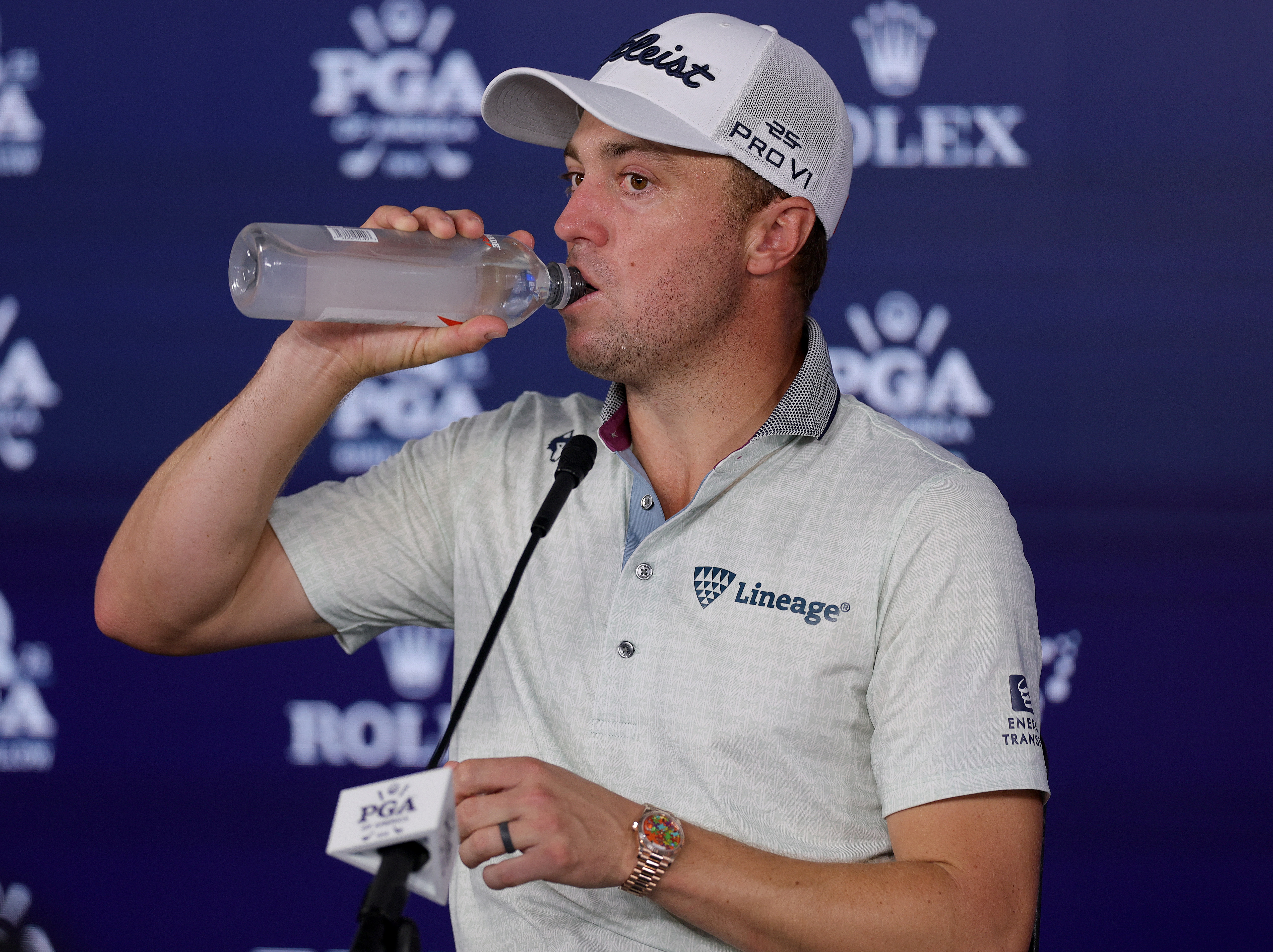 Justin Thomas drinks from a water bottle