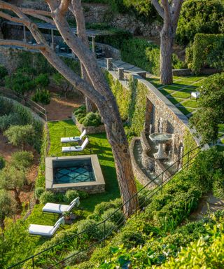 sun loungers by plunge pool on a terraced hillside mediterranean garden